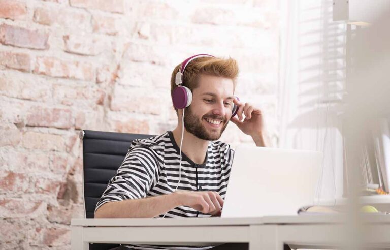 web developer with headphones at desk