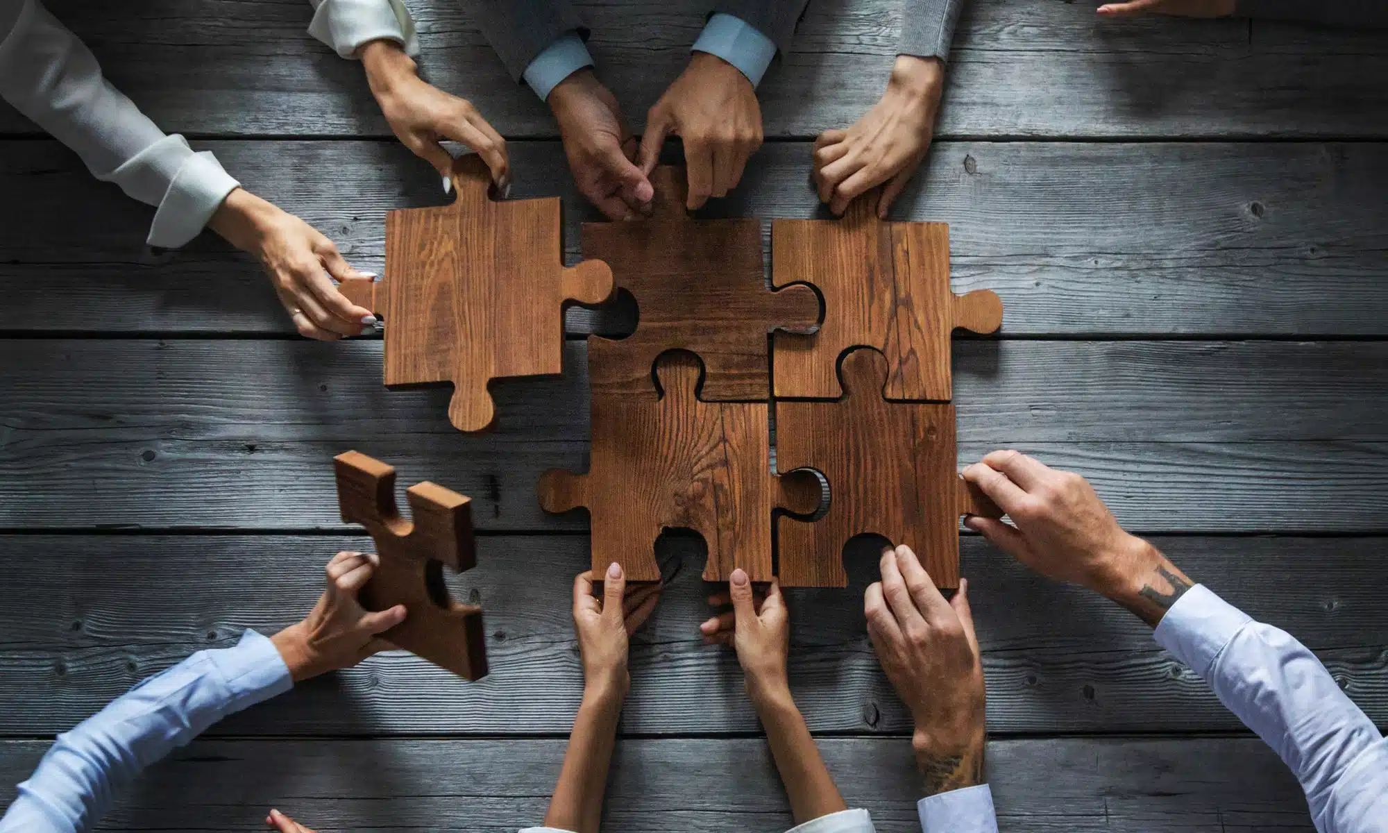 business-people-team-sitting-around-meeting-table-assembling-wooden-jigsaw-puzzle-pieces-unity-cooperation-ideas-concept Unveiling the Soul of a Brand